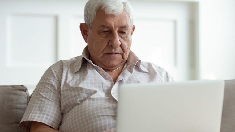 An older man looking on his laptop