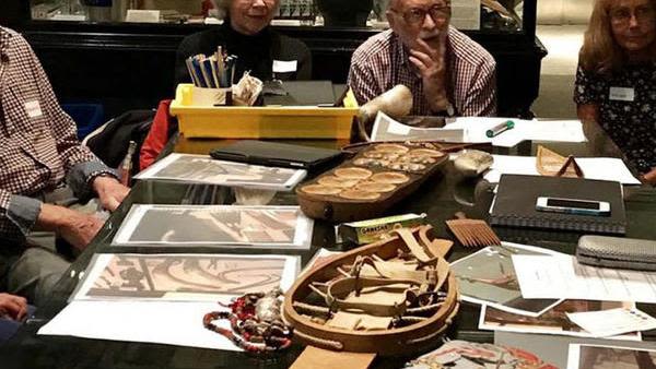 Group of older people sat around table at Pitt Rivers Museum